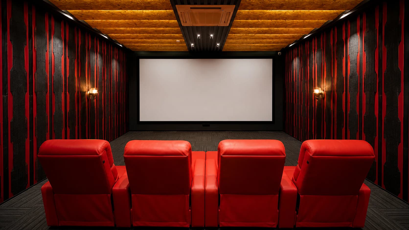 Completed private home theatre with tiered seating, acoustic wall treatment and calibrated screen wall.